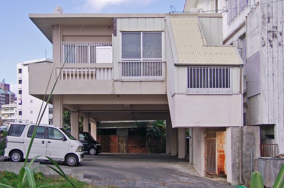 よくある沖縄の市街地の建物。一階部分がピロティで駐車場になっている